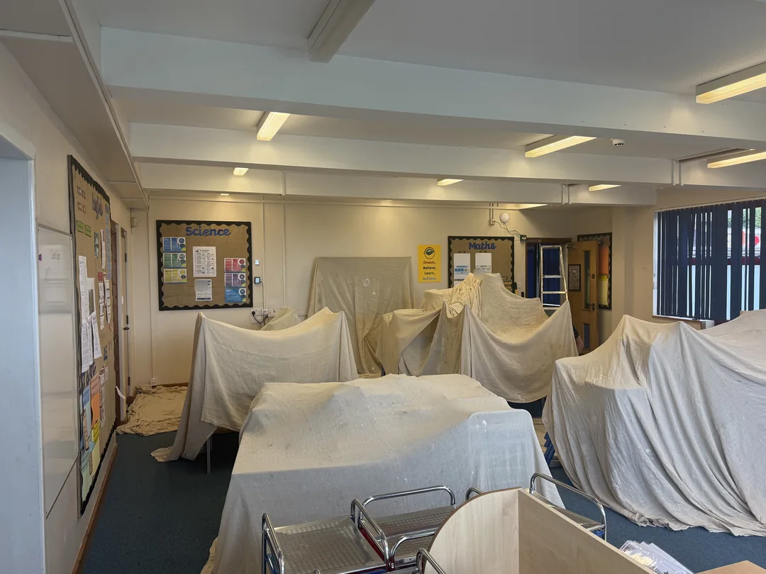 Classroom furniture covered while the surrounding surfaces were decorated.