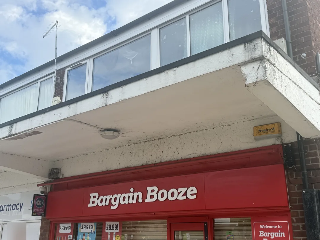 Shopfront canopy corner before preparation, repairs and redecoration.