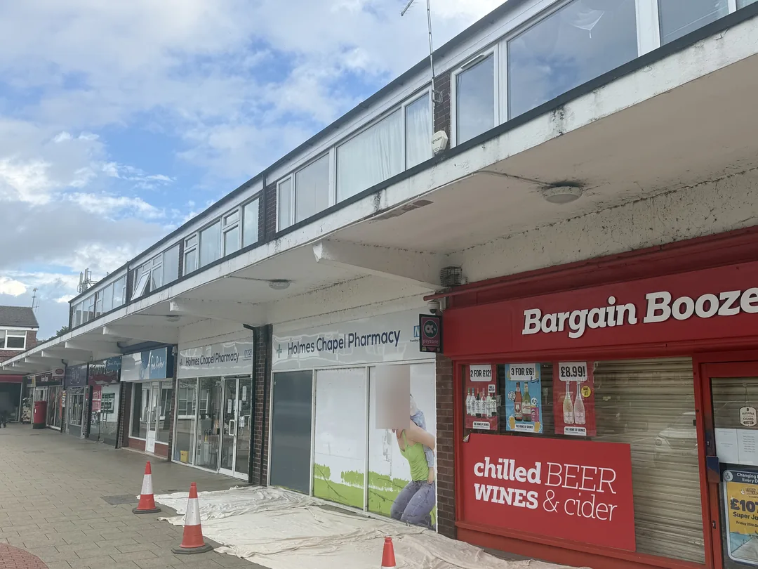 Shopfront canopy before redecoration, with the work area protected.