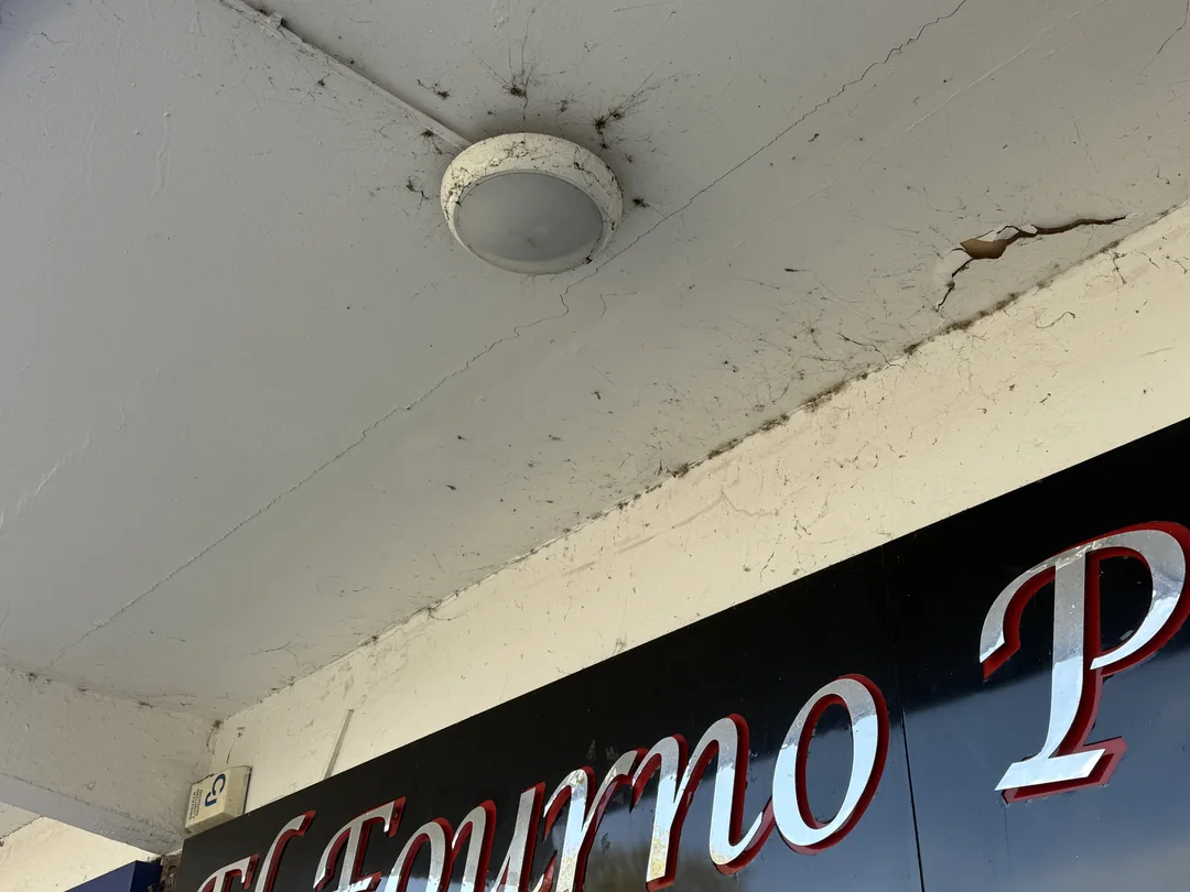 Shopfront canopy soffit around the light fitting before redecoration.