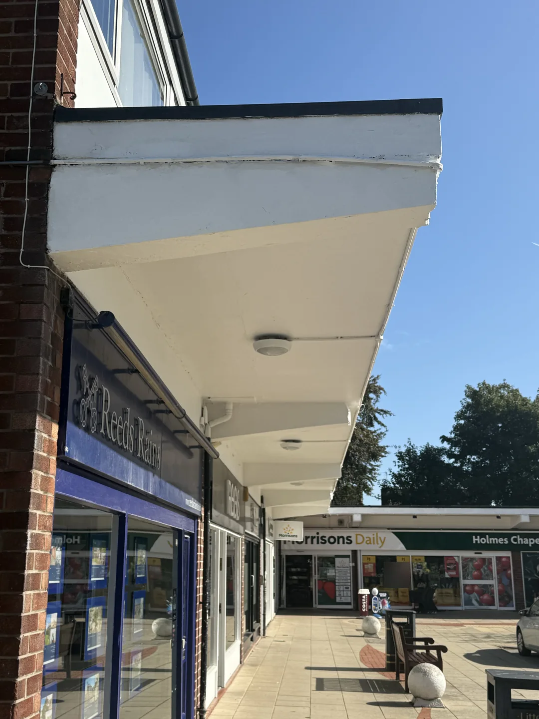 Finished canopy edge and soffit above the shopfronts on the other side of the precinct.