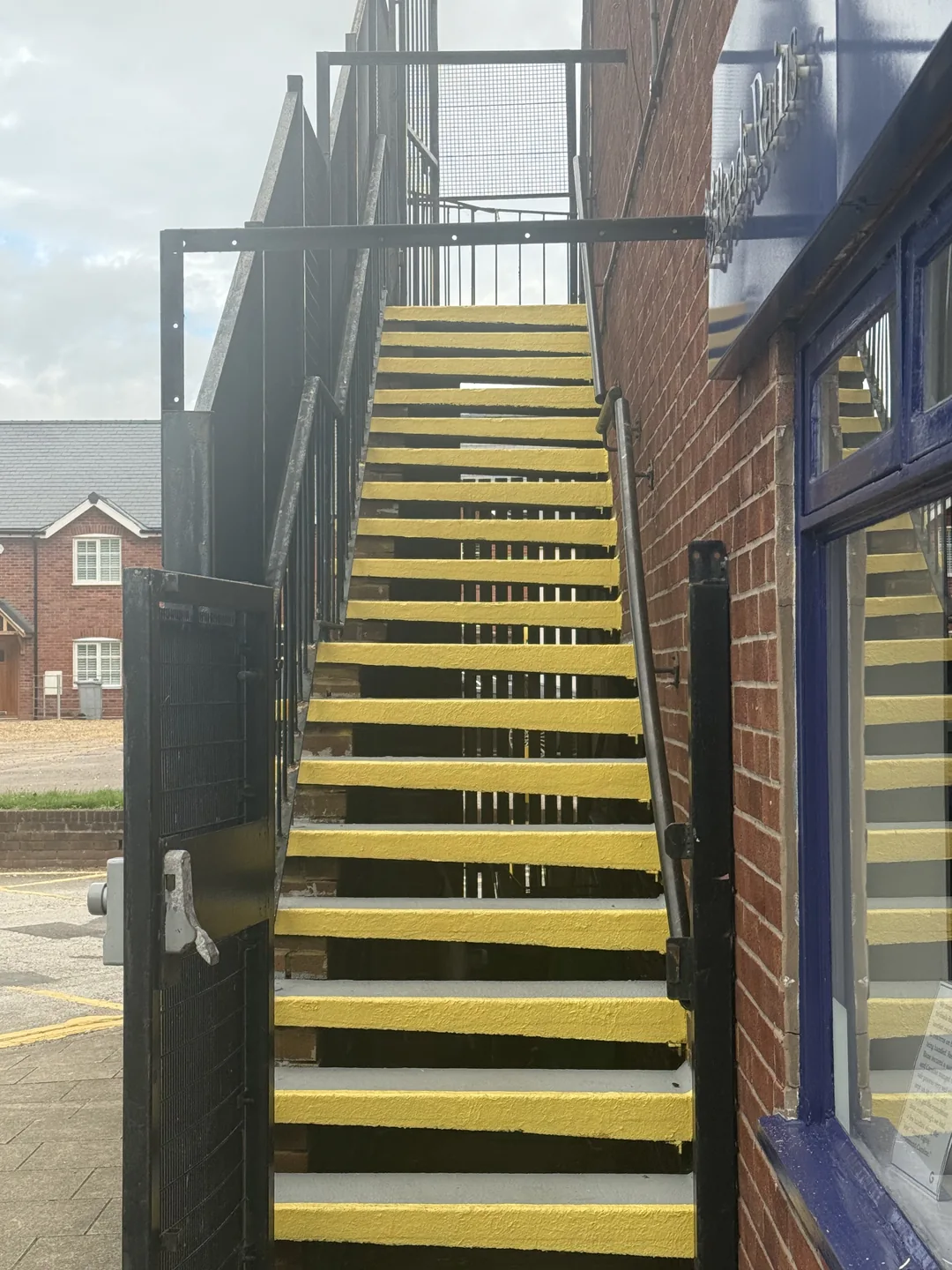 Grey treads and yellow nosings on the first external staircase after redecoration.
