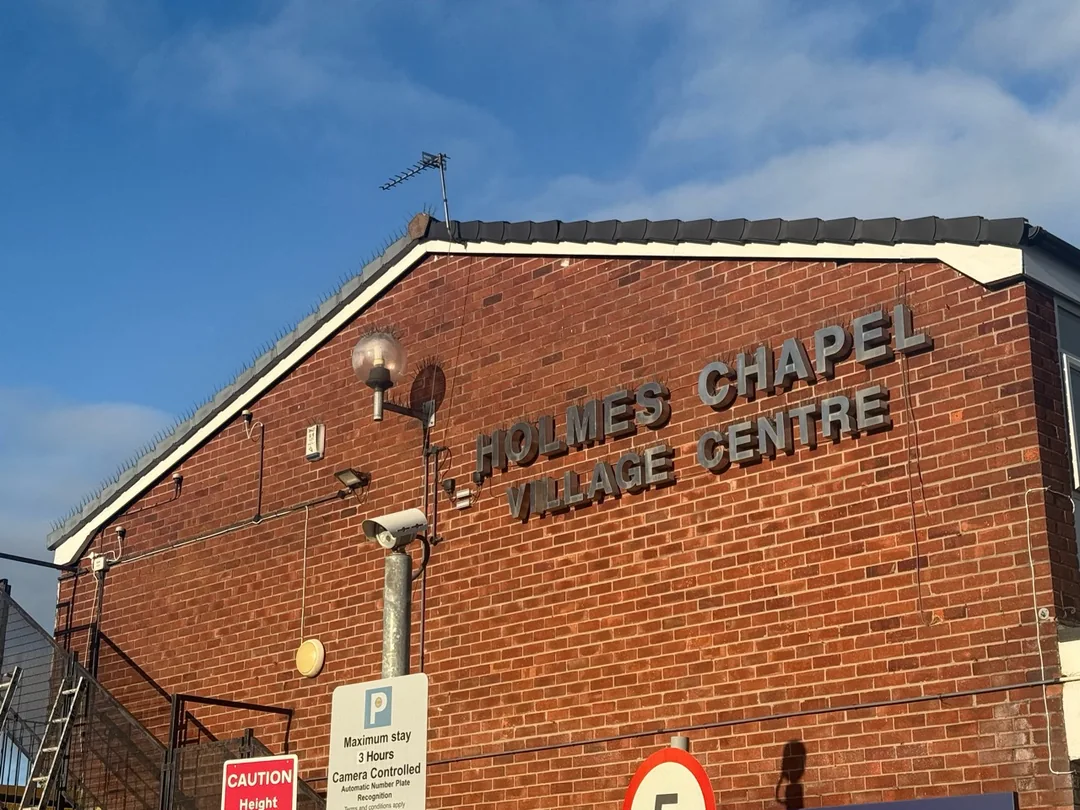 Finished white gable fascia above the Holmes Chapel Village Centre sign.