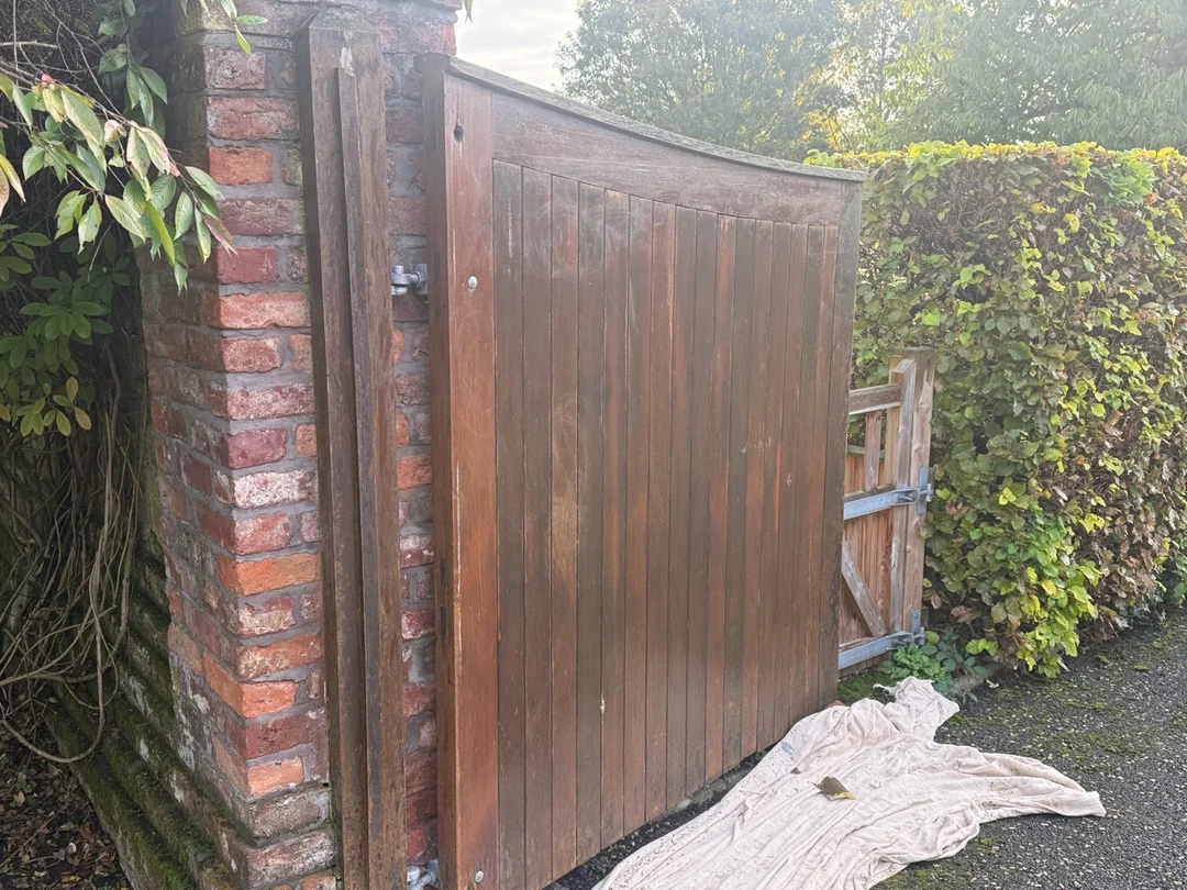 One driveway gate before the final finish, with protective sheets beneath the work area.