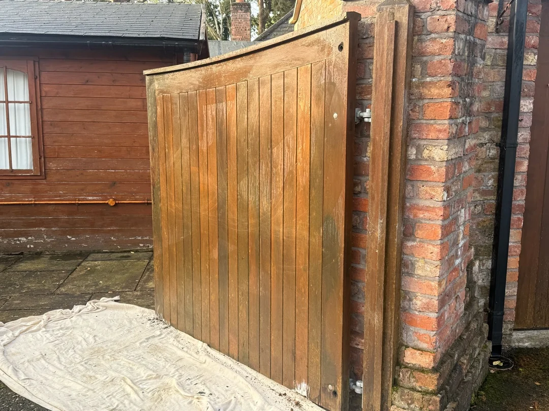 The other driveway gate before the final finish, viewed beside the brick pillar.