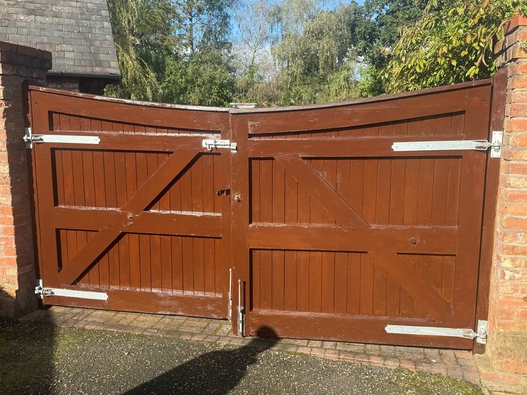 The driveway gates after repainting, showing the reverse faces and diagonal timber bracing.