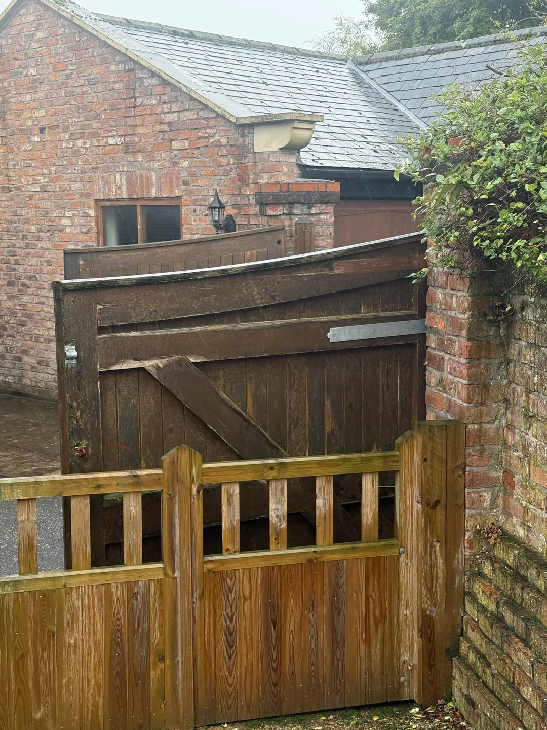 An earlier view of the driveway gates from inside the property, with the nearer gate open.