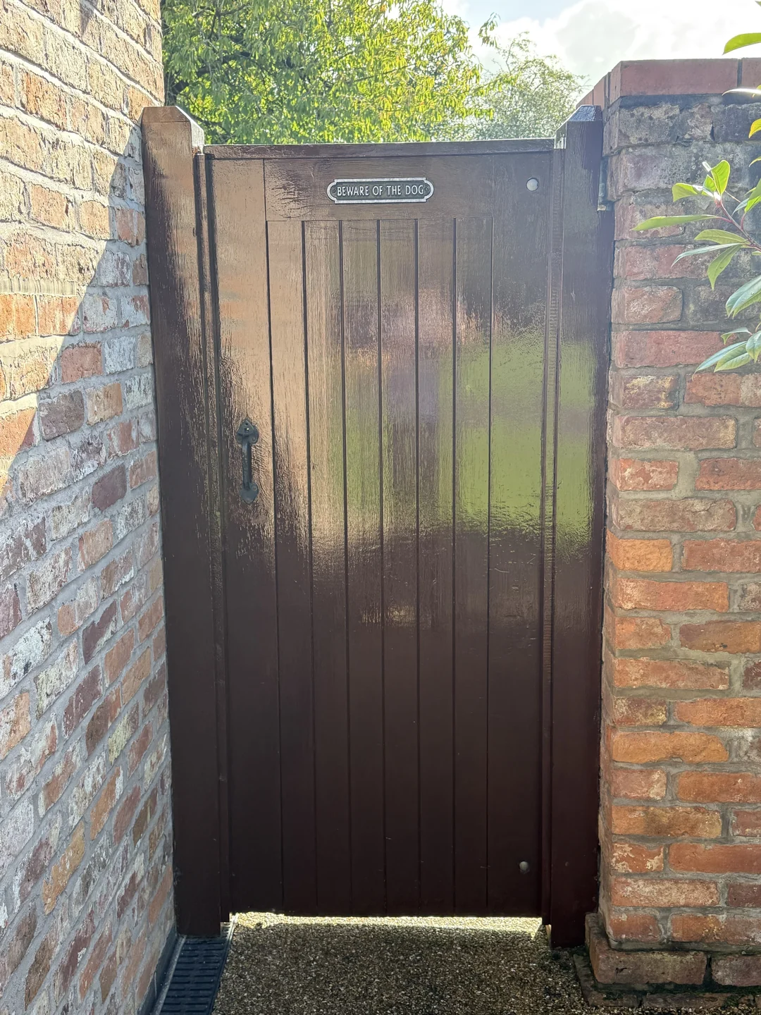 The front of the pedestrian gate after repainting, with the existing sign and handle retained.