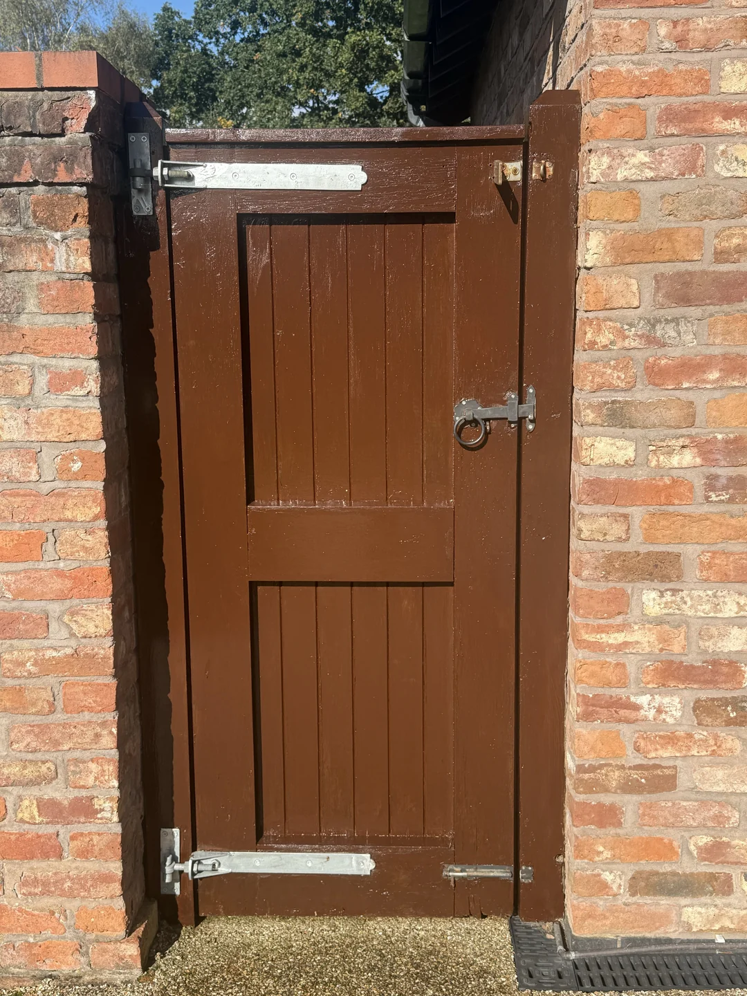 The reverse of the pedestrian gate after repainting, including its rails and surrounding posts.