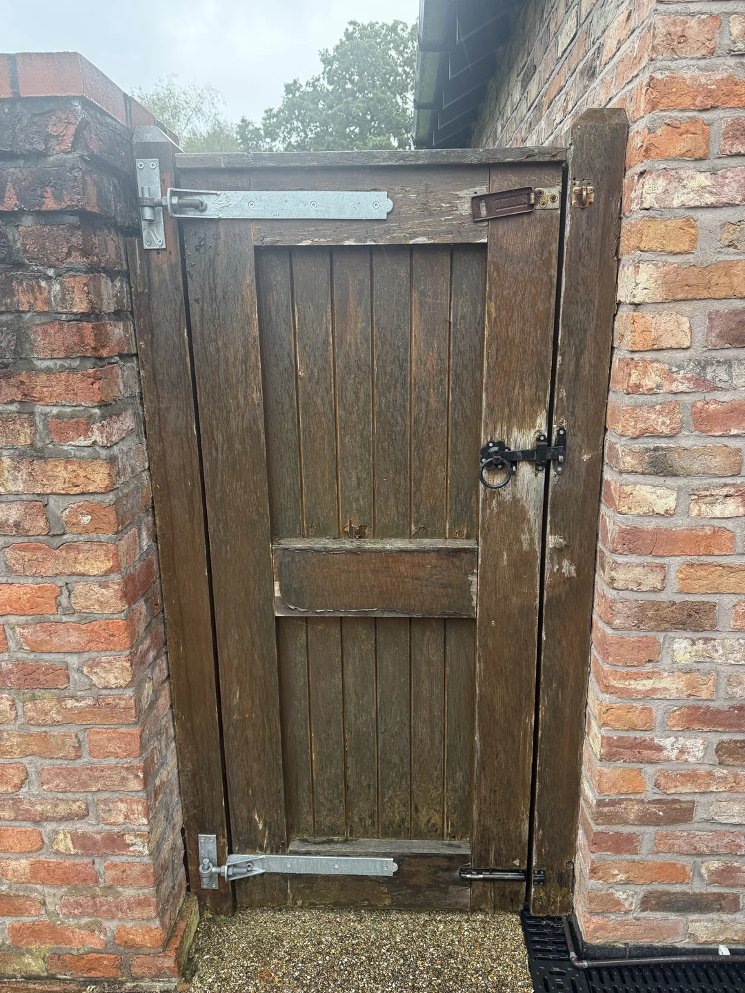 The pedestrian gate from the reverse side before repainting, with a worn and uneven existing finish.