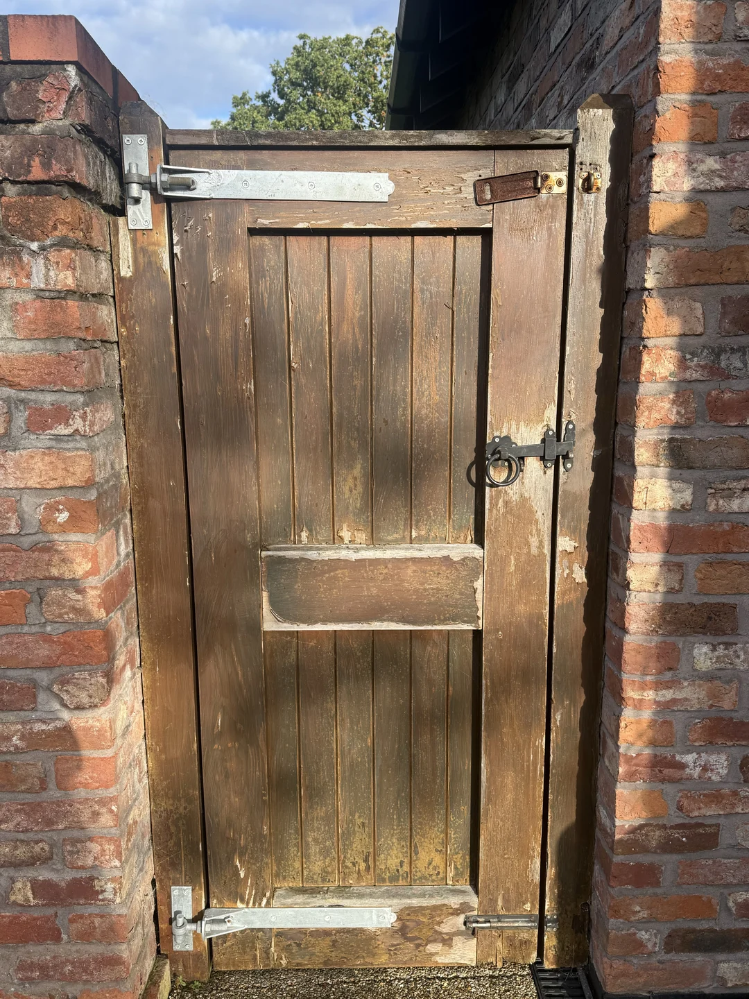 A closer view of the worn coating on the reverse of the pedestrian gate before repainting.