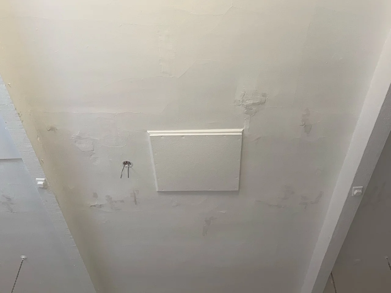 School ceiling around the access panel before preparation and repainting