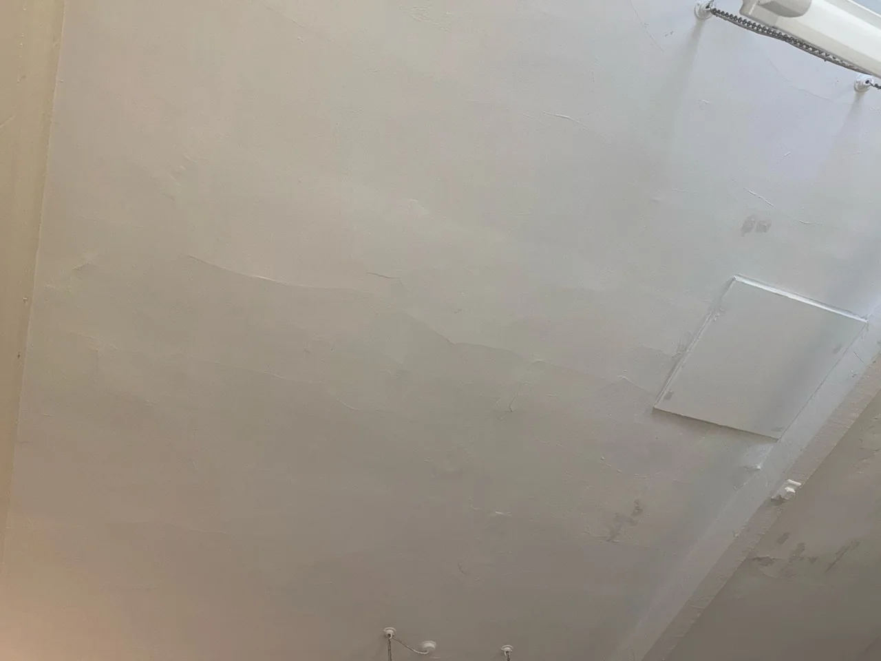 Ceiling surface beside the suspended light fitting before redecoration
