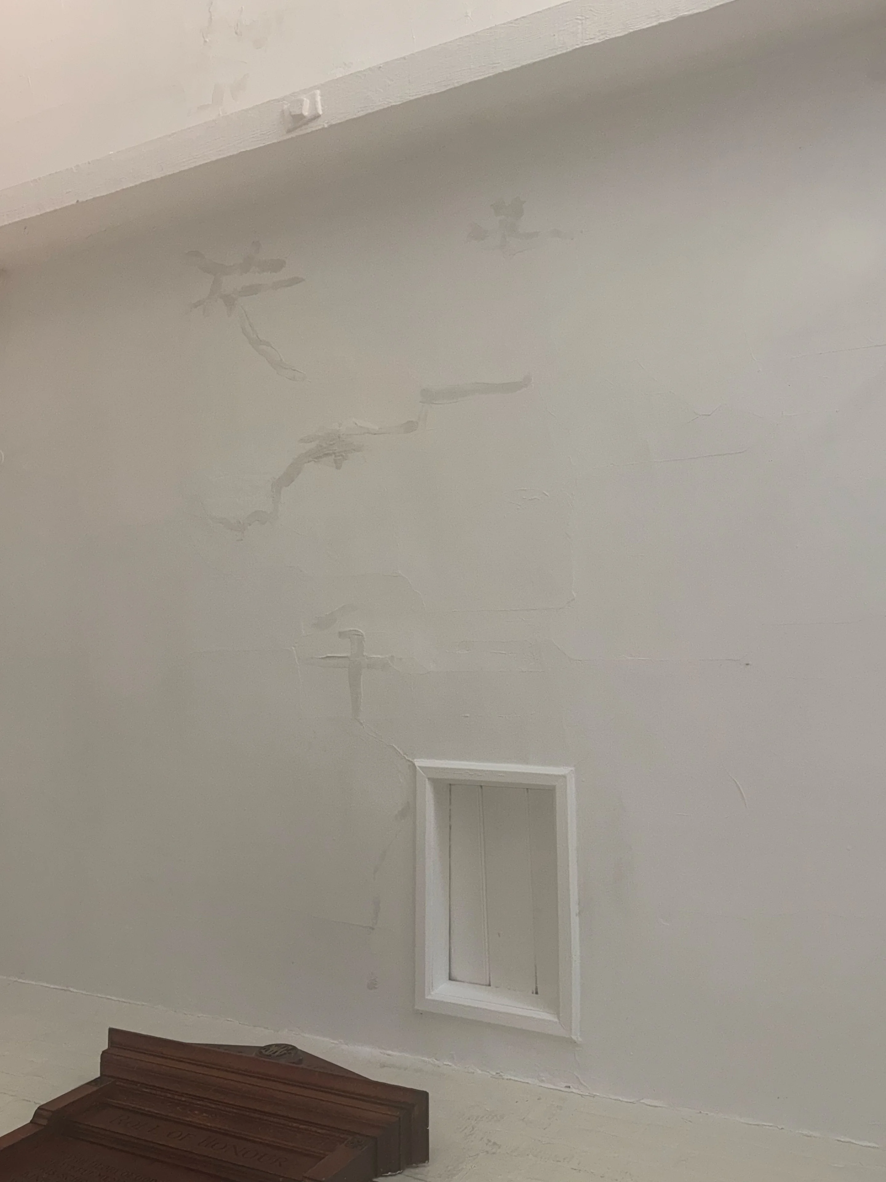 Cracked and uneven ceiling surface around the ventilation grille before decorating