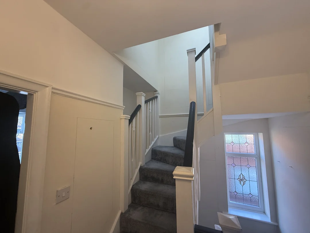 The landing and next stair section before the new wall treatment.
