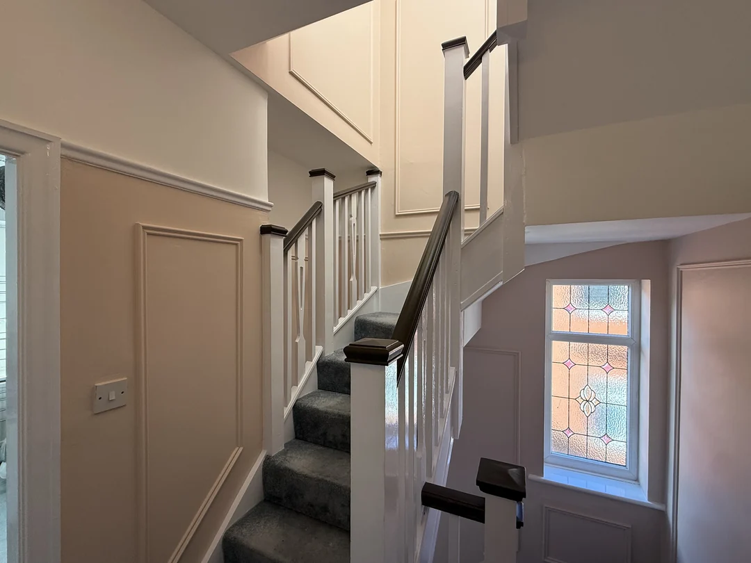 The completed stair section and painted wall panels beside the landing window.