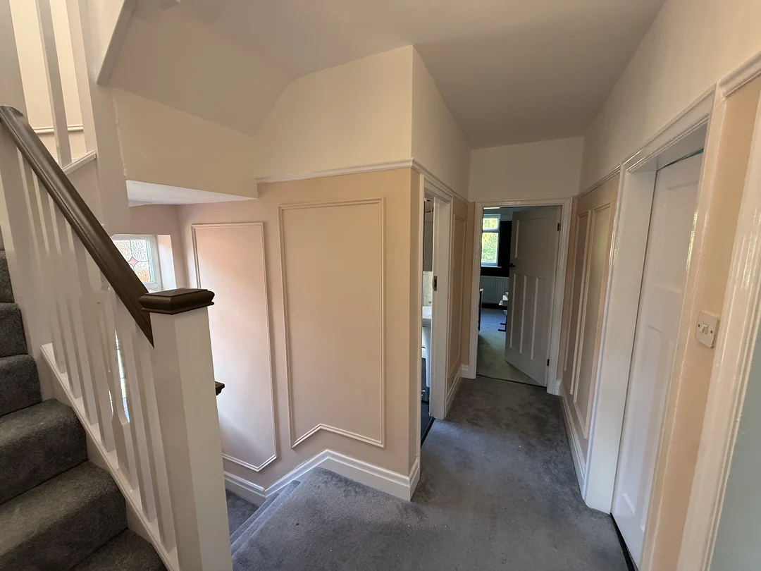 The finished landing wall panels where the stairs meet the corridor.