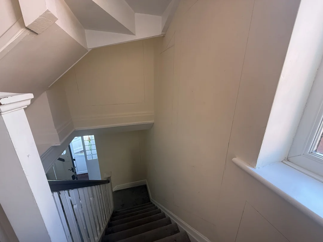 Earlier stage looking down the stairs, with pencil layout markings on the wall before fitting beading.