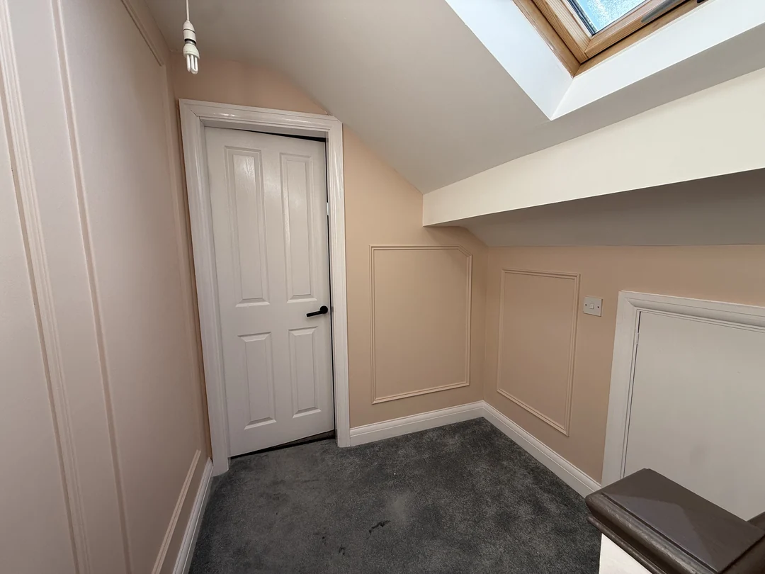 The finished upper landing with beading beneath the sloping ceiling.