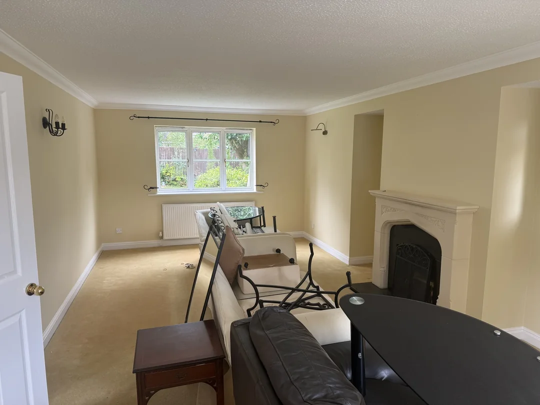 The living room after decoration, with cream walls around the original fireplace.