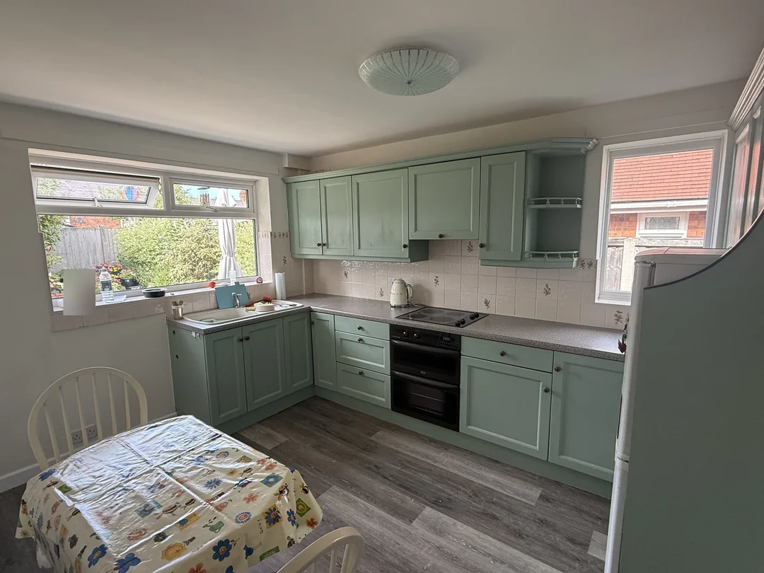 Kitchen cabinet fronts repainted in a soft green finish