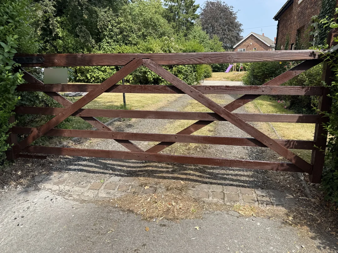 The timber field-style gate with its completed brown finish.