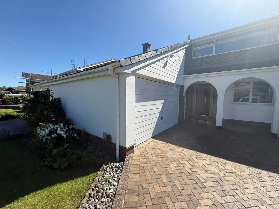 White finishes across the garage front and adjoining entrance.