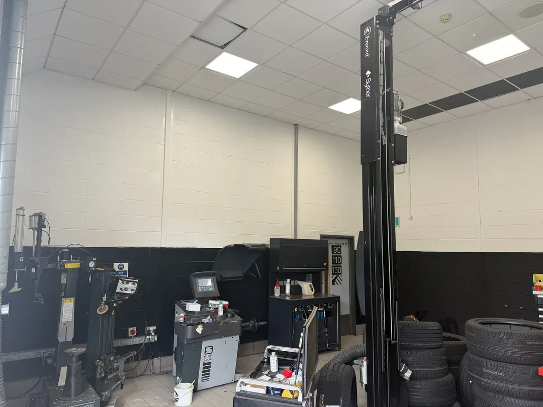Completed white upper walls and black lower band in a vehicle workshop bay